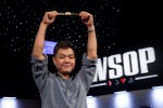 Yan Chen, Event 14 Bracelet winner, celebrates his victory on stage at the Bracelet Ceremony in the Pavilion Room in front of fellow poker players