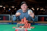 Jeffrey Tebben shows off his Event 24 Championship Bracelet, chips, and winning hand