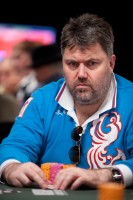 Sergey Altbregin watches the action at his table while clinching his cards.