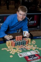 Joshua Tieman leans over his winning chip stack.